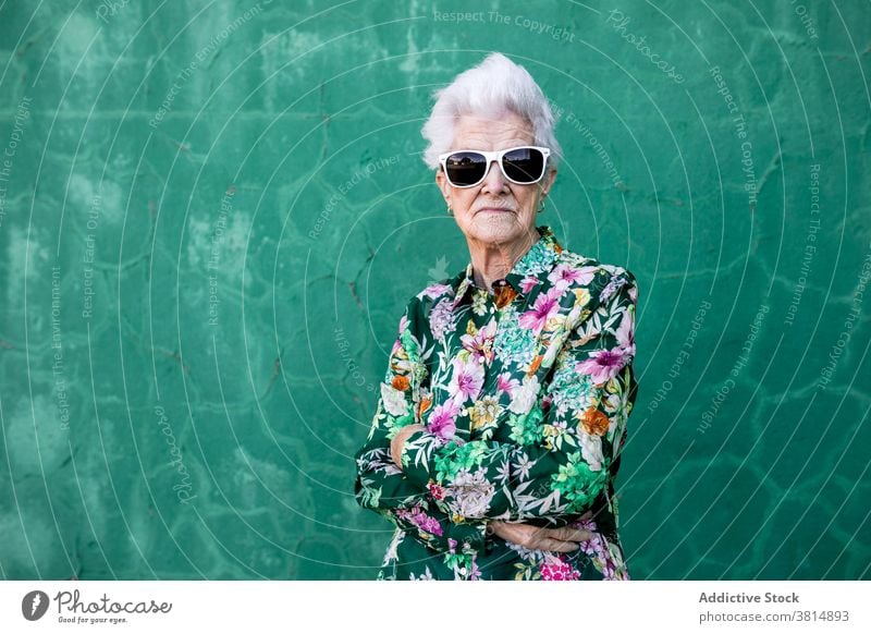 Stilvolle ältere Frau mit trendiger Sonnenbrille Senior trendy Hipster cool farbenfroh Outfit Mode urban Lifestyle hell Individualität verrückt Glück heiter