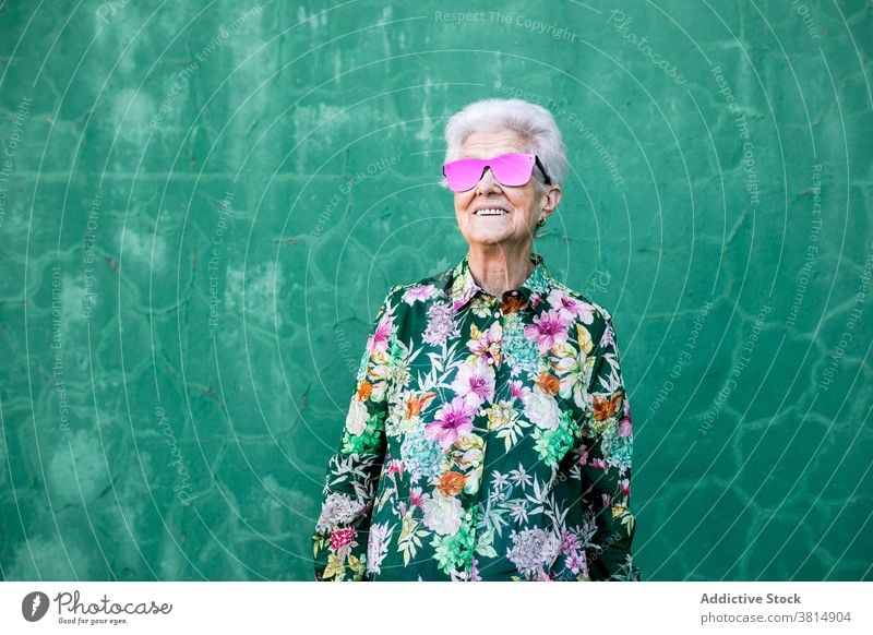 Stilvolle ältere Frau mit trendiger Sonnenbrille Senior trendy Hipster cool farbenfroh Outfit Mode urban Lifestyle hell Individualität verrückt Glück heiter