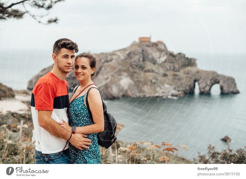 Junges Paar vor der Insel Gaztelugatxe Touristen Tourismus Besuch Sightseeing Ausflügler romantisch Vizcaya Spanien Bermeo X Jahrhundert Textfreiraum reisen