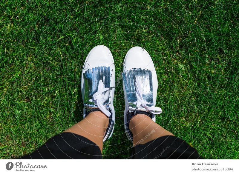 Junge Frau in weißen Turnschuhen, Draufsicht Schuhe Mode anhaben Stil Fuß Beine wandern Sport Jeanshose Straße Gras Park laufen oben Selfie Jeansstoff