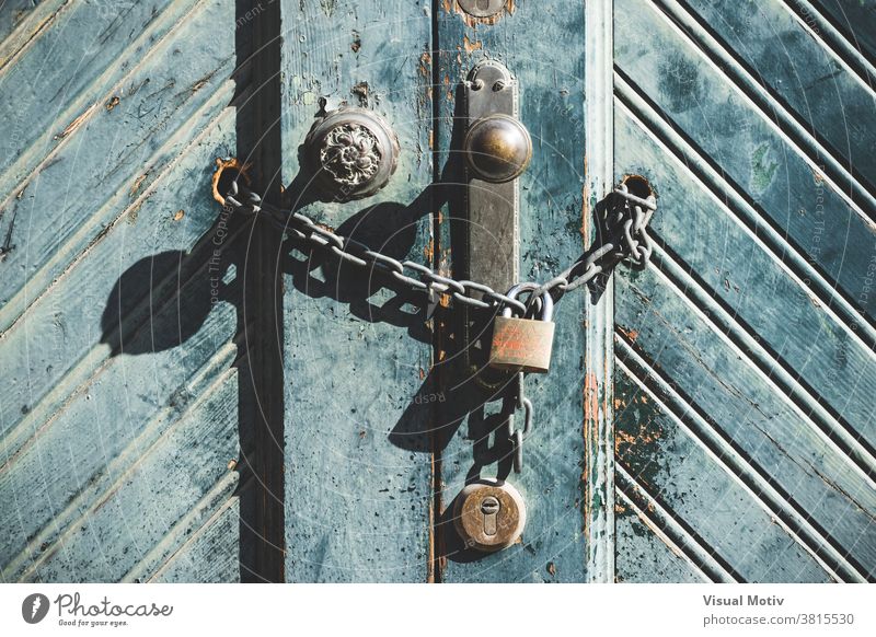 Knauf und Vorhängeschloss an einer verwitterten blauen Holztür einer alten Fabrik Tür Vorderseite Architektur Detailaufnahme abstrakt Außenseite urban hölzern