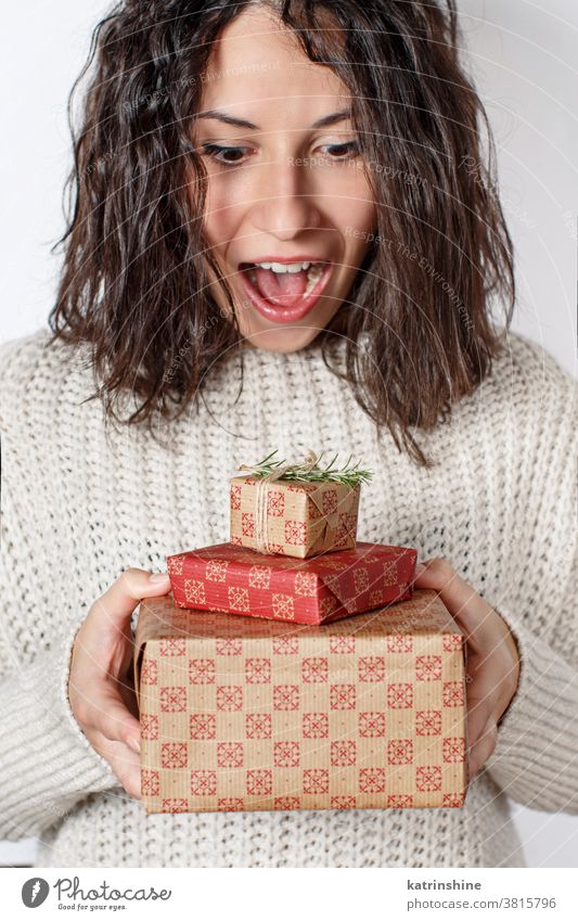 Überraschte junge Frau hält Geschenke aus nächster Nähe in der Hand Hände Geschenkverpackung Weihnachten überrascht Glück emotionalisiert weiß abschließen