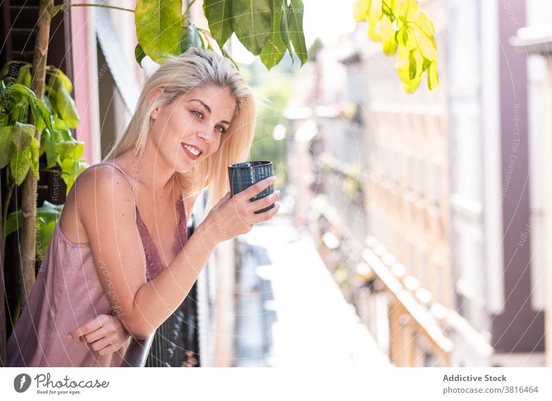 Junge Frau mit Tasse Kaffee genießt den Morgen auf dem Balkon Glück trinken genießen rein Lächeln sonnig jung Getränk Tee sich[Akk] entspannen heiter blond