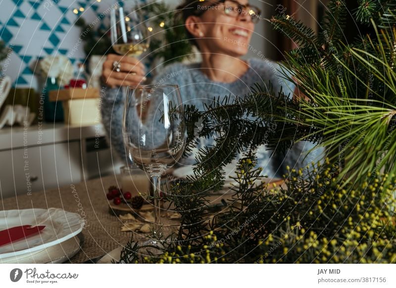 Familiengespräche beim Weihnachtsessen, zwei Schwestern sitzen am geschmückten Tisch mit Gläsern Weißwein in der Hand. Weihnachten Erntedankfest Abendessen