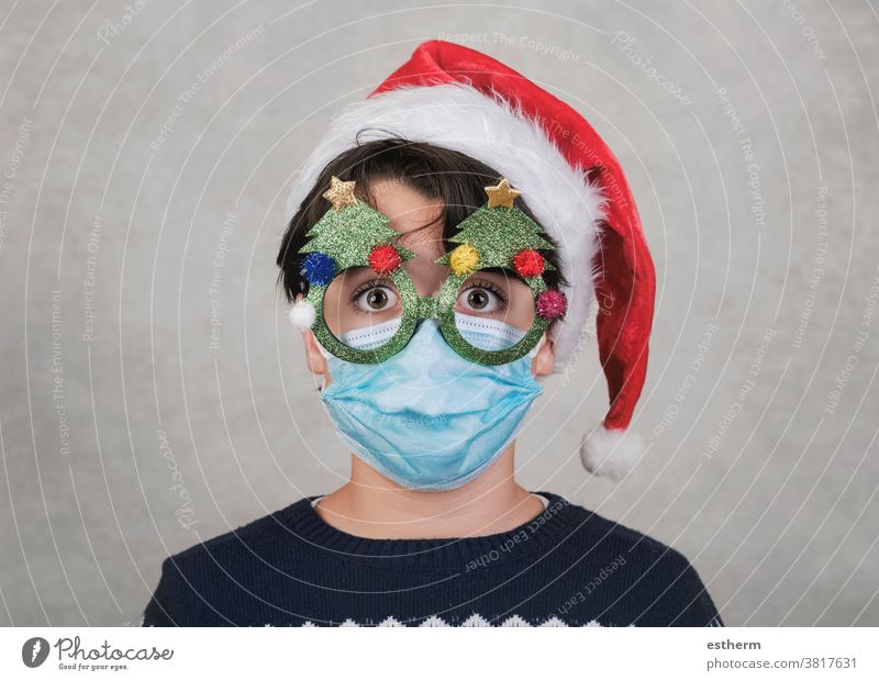 Frohe Weihnachten, Lustiges Kind mit medizinischer Maske und lustiger Weihnachtsbrille Weihnachtsmann Coronavirus medizinische Maske Heiligabend 2019-ncov
