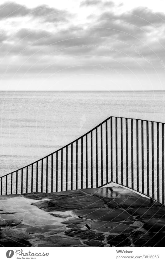 Die nasse Treppe führt herunter zum Strand Meer Geländer Stufen Stein Wasser Wolken Himmel Regen feucht Menschenleer Küste Ostsee grau trüb melancholisch See