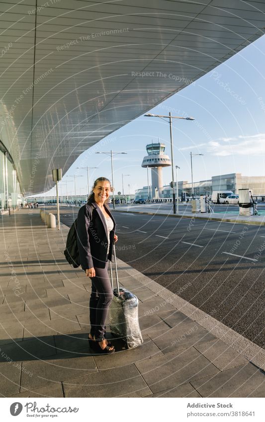 Lächelnde reisende Frau mit Koffer im Flughafen heiter Reisender Sommer Wochenende Station Rucksack Tourist Gepäck Feiertag Tasche Ausflug Urlaub Tourismus