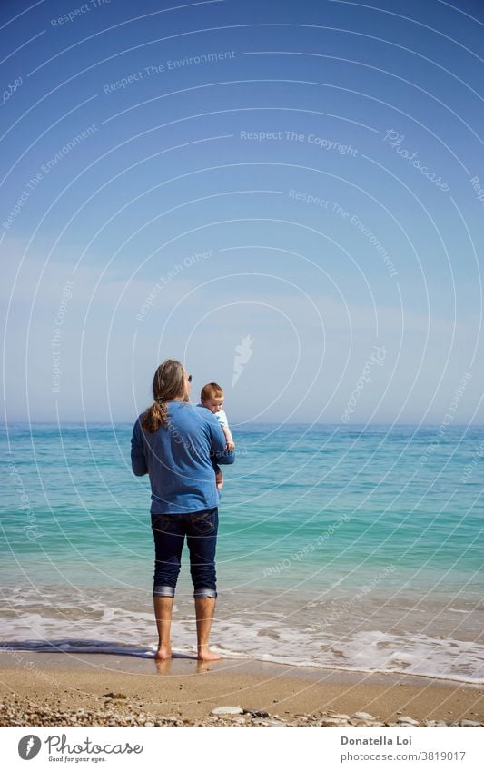 Vater und Sohn am Strand Baby Barfuß Windstille Kind Kindheit Textfreiraum Tag tagsüber von hinten Beteiligung kleiner Junge auf das Meer schauen Mann Natur