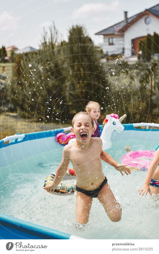 Junge springt und planscht in einem Pool authentisch Hinterhof Kindheit Kinder Familie Spaß Garten Fröhlichkeit Glück Freude Lachen Lifestyle spielerisch