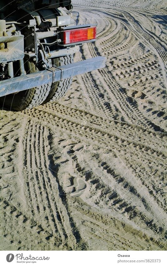 LKW und Reifenspuren auf einer Baustelle Heck Rücklicht Rückseite Abdrücke Lastwagen Stoßstange Sand Boden Erde Erdarbeiten Fahrzeug Außenaufnahme