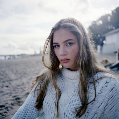Blondes Mädchen in weißem Strickpullover am Ostseestrand Landschaft Strand intensiv jugendlich freundlich Natur weiblich einzigartig außergewöhnlich