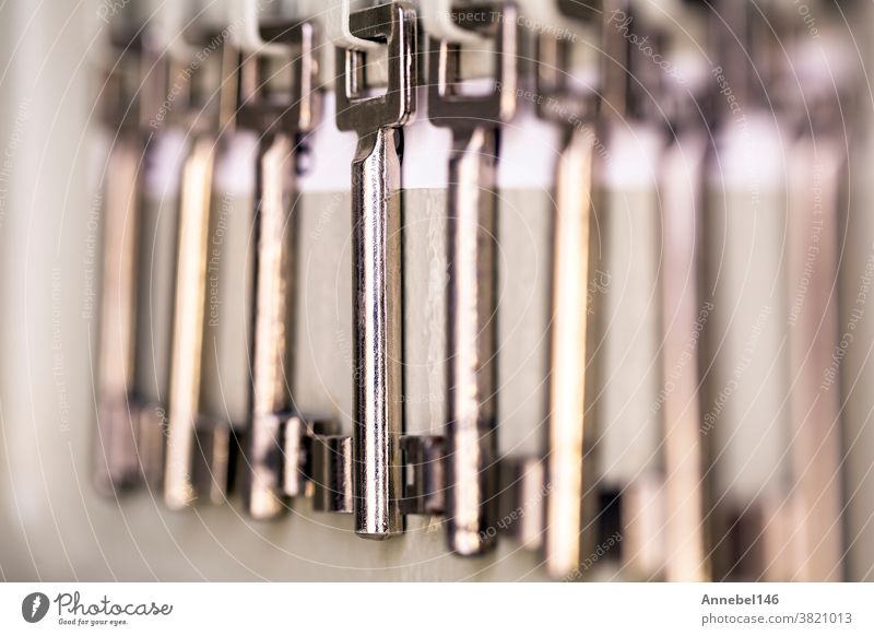 Reihe von alten silberfarbenen Metallskelettschlüsseln, die in einem Regal mit den Zimmernummern hängen. antike Vintage-Schlüssel Stahl Silber Schloss Taste