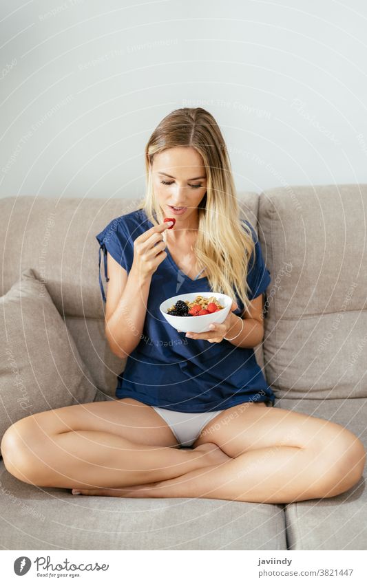 Junge Frau isst eine vegane Vorspeise mit Nüssen, Himbeeren und Brombeeren. Gesundheit Lebensmittel Diät Veganer Vegetarier Mädchen Mahlzeit Amuse-Gueule frisch