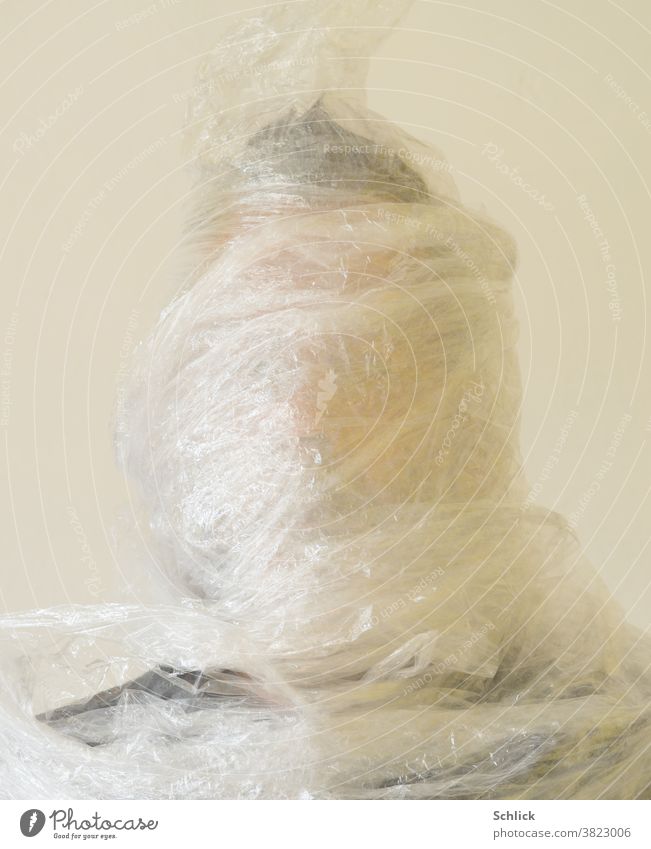 Plastikwahn Kopf eines Mannes mit  Stretchfolie umwickelt Folie Portrait Umweltschutz Plastikmüll Müll Verpackung Verpackuungsmüll ersticken Selfie frontal hell