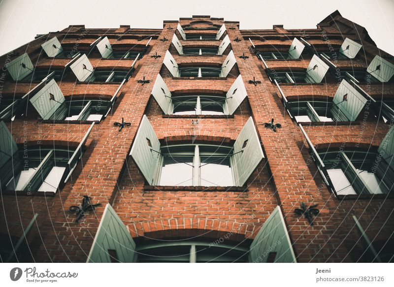 Giebel eines alten roten Backsteinhauses. Die mintfarbigen Fensterläden sind symmetrisch geöffnet Fassade Fensterladen Symmetrie grün Haus Mauer Mauerwerk