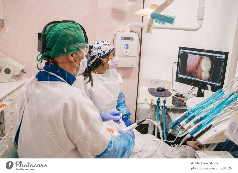 Anonymer Arzt in der Nähe des Patienten und Computer mit Bild der Zähne dental Bildschirm geduldig professionell medizinisch Gerät Klinik Krankenpfleger Frauen