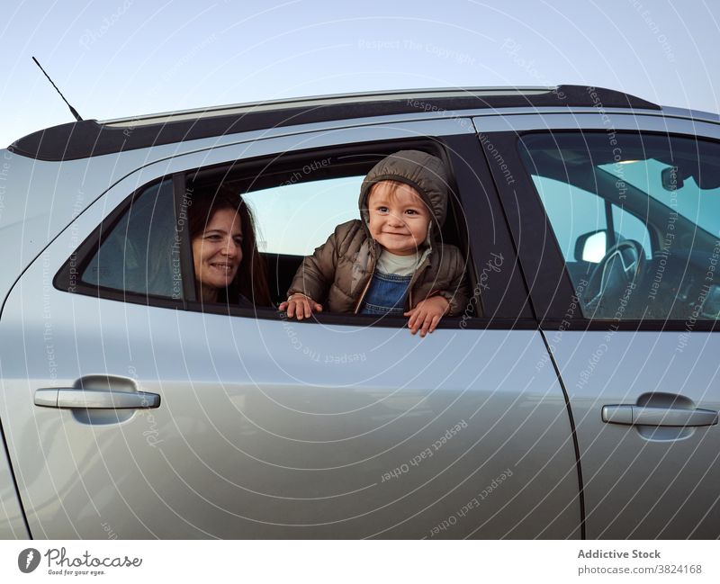 Mutter und Kind zusammen im Auto Peer PKW Fenster neugierig Zusammensein Automobil Rücksitz Kleinkind niedlich heiter Sitz Verkehr Fahrzeug wenig Lächeln reisen