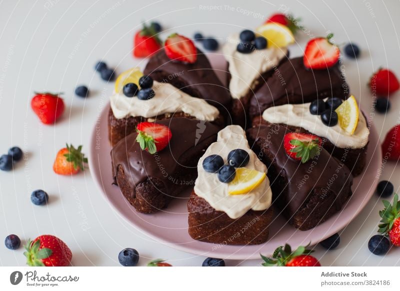Schokoladenkuchen mit Beeren und Zitrone Kuchen Spielfigur selbstgemacht Dessert süß Gebäck gebacken Sahne köstlich Blaubeeren Erdbeeren Belag geschnitten