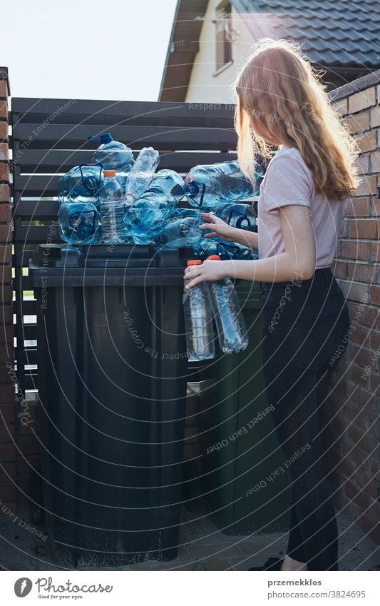 Junge Frau wirft leere gebrauchte Plastik-Wasserflaschen in den Mülleimer Behälter blau Flasche abholen sammelnd Container zerdrückt Entsorgung Ökologie Umwelt