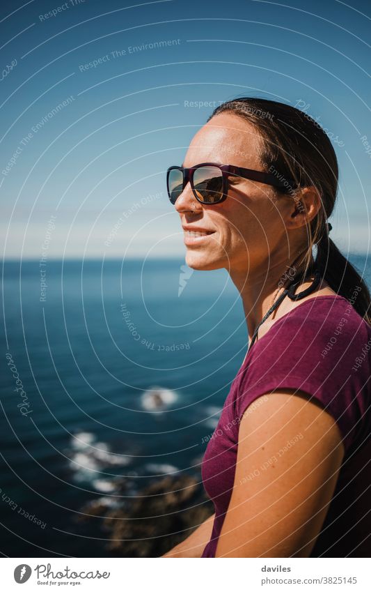 Weiße Frau mit Sonnenbrille, die den Blick von einer Klippe im Atlantischen Ozean genießt. Seeküste Europa Norden Europäer Spanien Asturien brights Gesicht