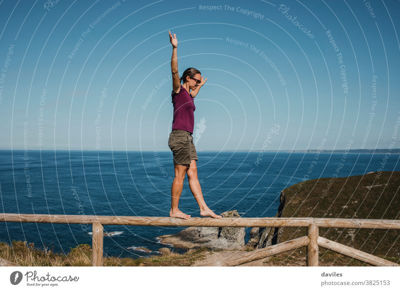 Frau geht und balanciert auf einem hölzernen Geländer an der Küstenlinie. sportlich im Freien Lifestyle Urlaub Sommer MEER Person Wasser Gleichgewicht reisen