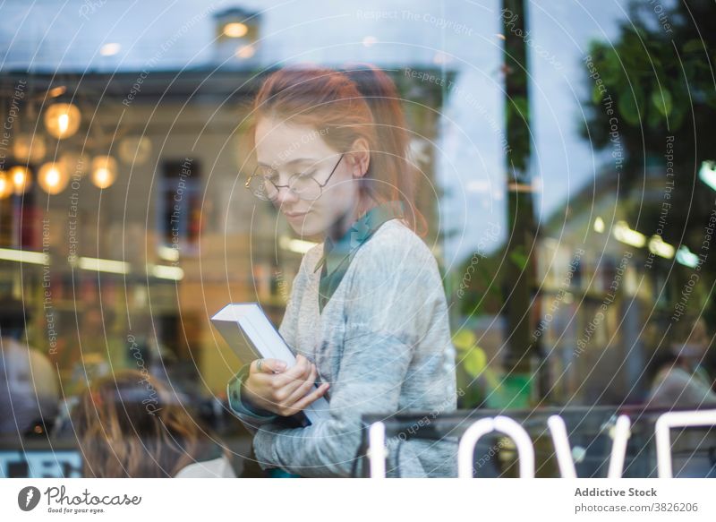 Frau mit Buch in moderner Buchhandlung Buchladen Stil sich[Akk] entspannen gemütlich Schüler Bildung jung Brille lässig sitzen trendy Lautstärke Literatur Roman