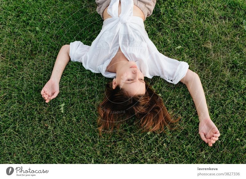 Oben Aufnahme einer auf grünem Gras liegenden Frau Mädchen Lifestyle Erwachsener Person im Freien Park Glück Draufsicht oben gesichtslos Hände Sommer