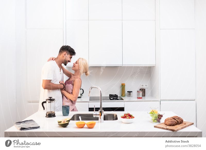 Fröhliches Paar umarmt in der Küche zu Hause Frühstück heimwärts Umarmung Zusammensein Morgen heimisch Liebe Freude Partnerschaft Zuneigung romantisch Freundin