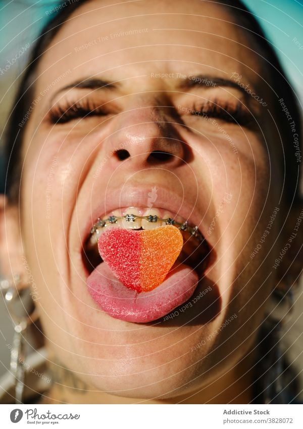 Ausdrucksstarke Frau mit Gummibonbon im Mund gummiartig Bonbon exzentrisch ausspannen rausstrecken süß Leckerbissen expressiv Klammer Zunge Dessert Zucker