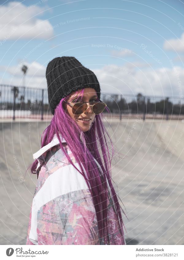 Stilvolle Frau mit rosa Haaren in Rollschuhen Rolle Skateplatz Schlittschuh Hipster Streetstyle informell exzentrisch Vorschein Hobby Spaß haben Outfit Straße