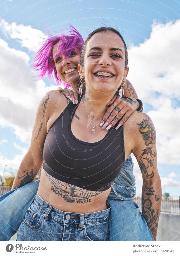 Fröhliche Frauen haben Spaß zusammen im Skatepark Huckepack Spaß haben Freund Freundschaft informell Tattoo Zusammensein Subkultur cool Freude Lachen Optimist