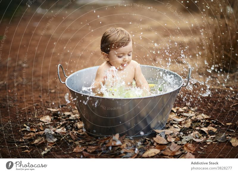 Adorable Baby spielt mit spritzendem Wasser im Bad im Freien spielen platschen Kindheit Spaß haben sorgenfrei Augen geschlossen Bewegung Tropfen Kleinkind