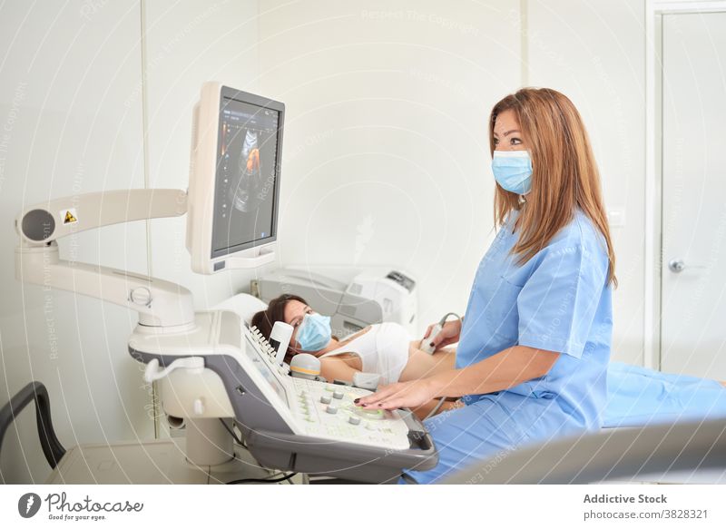 Weiblicher Ultraschalltechniker, der einen Patienten diagnostiziert, während er ein Sonographiegerät benutzt Techniker diagnostizieren geduldig Scanner Monitor