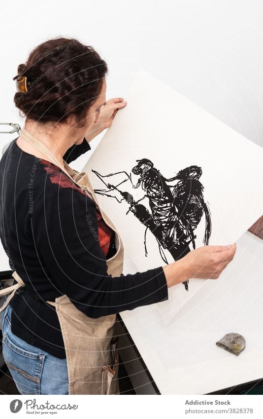 Künstler hält Papier mit Linolschnitt Druckgrafik drucken Eindruck kreieren Handwerk Kunstgewerbler professionell Kunstwerk Handwerkerin linocut Tusche Frau