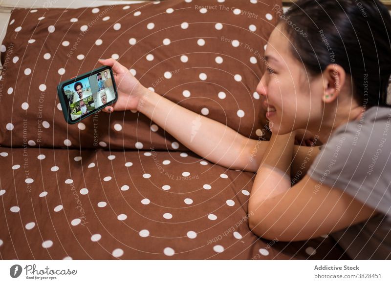 Asiatische Frau macht Videoanruf auf Smartphone zu Hause Coronavirus Selbstisolierung soziale Distanzierung Kommunizieren Video-Chat liegend online Sitzung