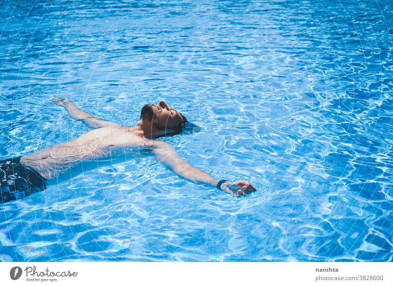 Junger Mann genießt den Tag im Schwimmbad Pool Schwimmsport spielerisch Sommer Wasser attraktiv cool frisch Feiertage Spaß lustig Sport sportlich Badehose