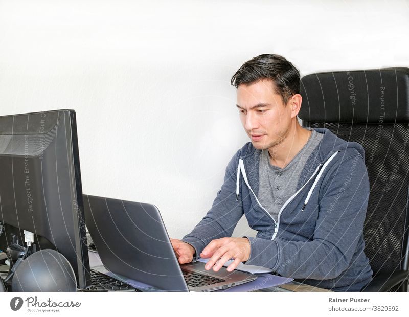 Mann in legerer Kleidung, der von zu Hause aus mit einem Laptop im Wohnzimmer arbeitet Erwachsener lässig Kaukasier Mitteilung Computer Textfreiraum Unternehmer