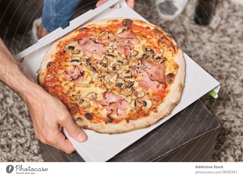 Crop anonymen Mann essen leckere Pizzen Pizza Lebensmittel Wochenende geschmackvoll Fastfood Mahlzeit Abendessen Mittagessen Scheibe appetitlich heimwärts ruhen