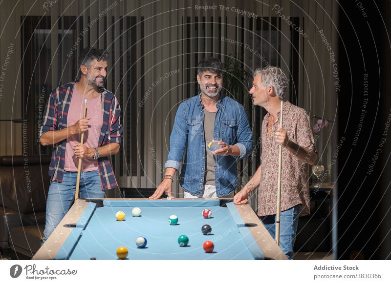 Fröhliche Männer spielen Billard, während sie Zeit miteinander verbringen Freundschaft Wochenende Freizeit Hobby Spiel Kälte genießen Lächeln Zusammensein