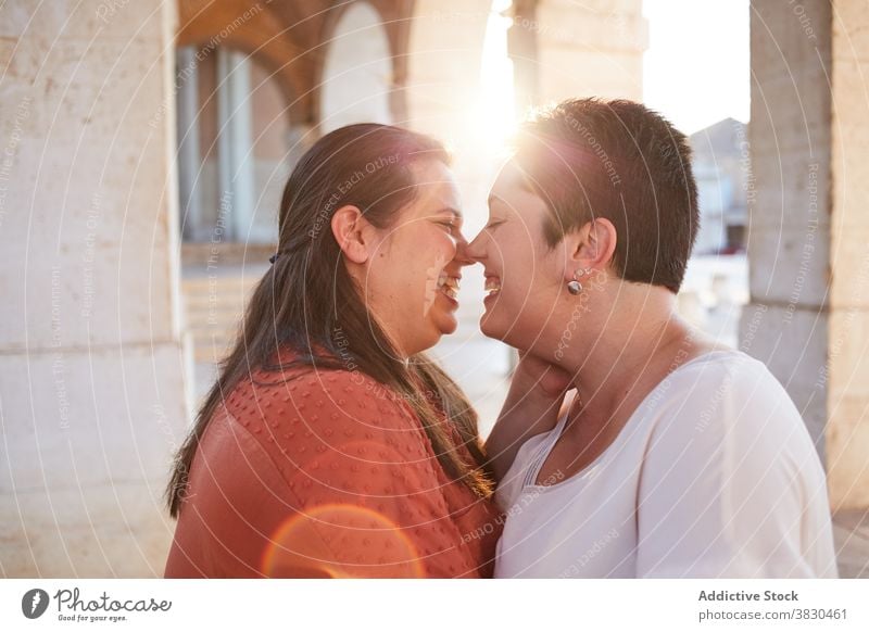 Lesbische Paar küssen auf der Straße in der Sonne Kuss lesbisch Liebe Partnerschaft Augen geschlossen Vergnügen sanft Frauen Sonnenschein Moment Harmonie