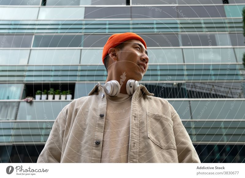 Emotionslos asiatischen Mann stehen gegen moderne Gebäude urban Kondominium Fassade Konzentration nachdenklich besinnlich nachdenken Fokus Gang Vorschein
