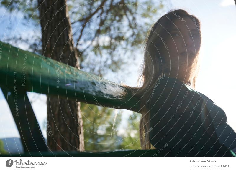 Entspannte Frau, die auf einer Bank im Wald ruht nachdenken sich[Akk] entspannen ruhen Sonnenlicht Natur Wälder Windstille friedlich besinnlich träumen