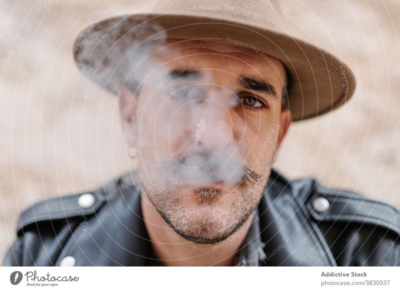 Ernster, nachdenklicher Mann mit Hut, der raucht cool Rauch Zigarette Schnurrbart Hipster brutal ruhen nachdenken männlich friedlich modern selbstbewusst