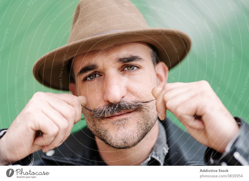 Ernster Mann mit Schnurrbart im Hut Locken Lederjacke männlich so tun, als ob Metrosexualität Optimist selbstbewusst freundlich trendy Typ Zeitgenosse reif