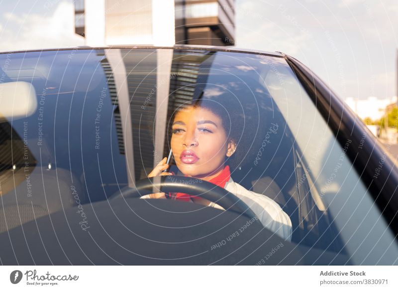 Ernste schwarze Frau fährt Auto und spricht auf Smartphone Fahrer Anruf benutzend sprechen Gespräch ernst selbstbewusst beschäftigt Arbeit Verkehr Mobile