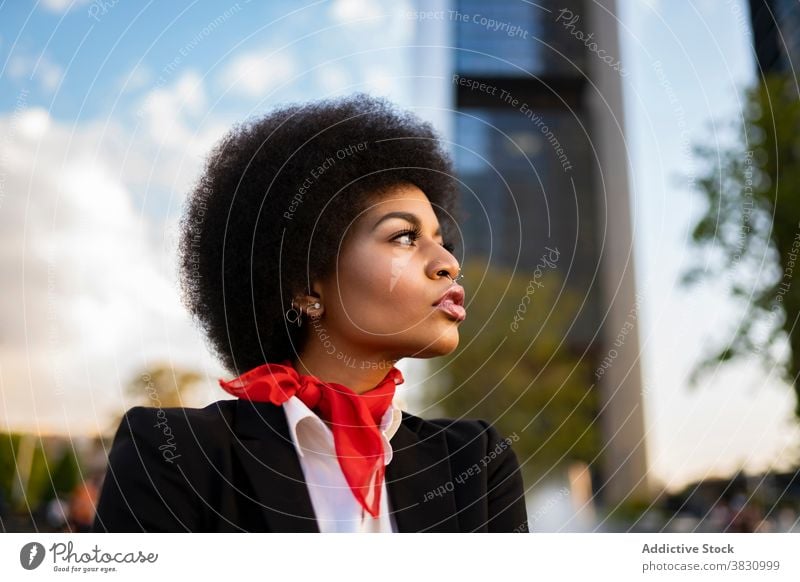 Stilvolle schwarze Frau steht in der Nähe in der Stadt ernst formal selbstbewusst cool elegant Windstille nachdenklich Vorschein Afro-Look Piercing