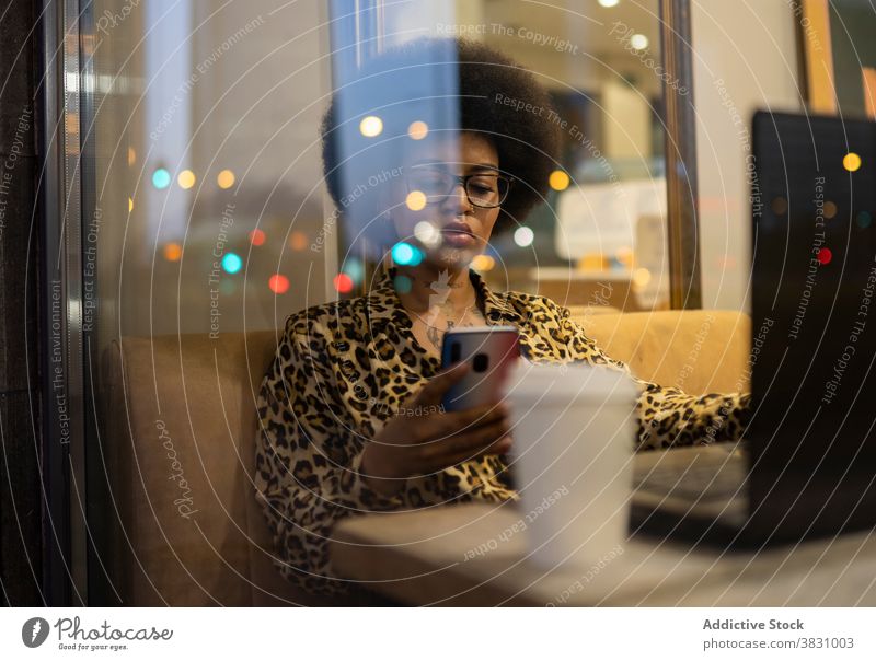 Nachdenkliche schwarze Frau mit Smartphone im Café ernst benutzend freiberuflich abgelegen selbstbewusst Internet Texten Unternehmer Surfen Browsen Funktelefon