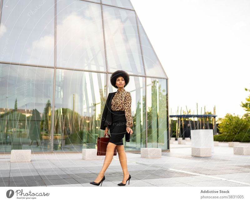 Pensive schwarze Geschäftsfrau in formalen Outfit in der Nähe von modernen Turm Frau Unternehmer Exekutive Optimist Stil selbstbewusst respektabel nachdenklich
