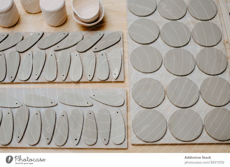 Verschiedene Stücke aus Ton auf dem Tisch in der Werkstatt Töpferwaren Material vorbereiten Hobelbank Form Atelier Steingut Tonwaren Handwerk handgefertigt