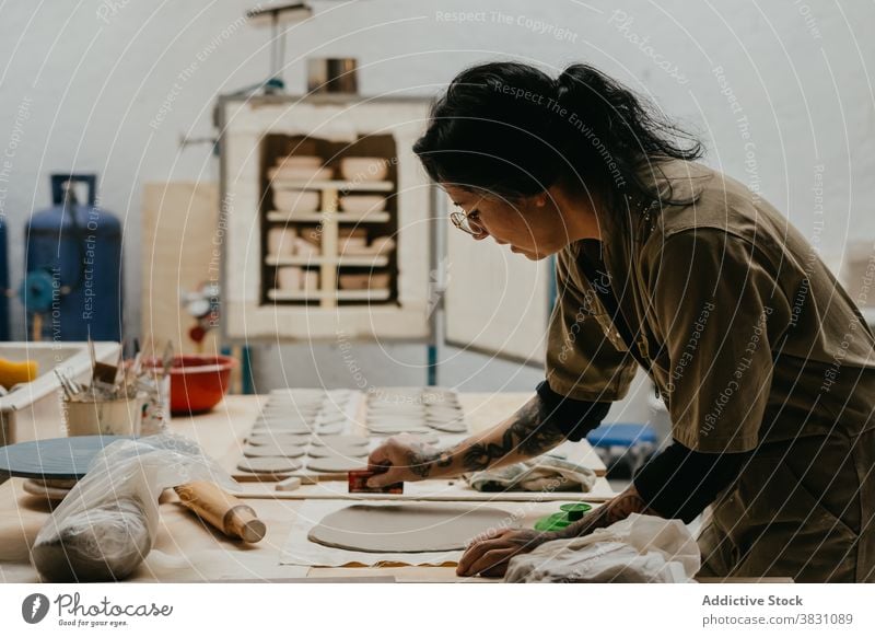 Keramikerin stellt in ihrer Werkstatt handgefertigte Tonwaren her kreieren Kunstgewerbler Töpferwaren Steingut Material Werkzeug stechend Spielfigur Basteln